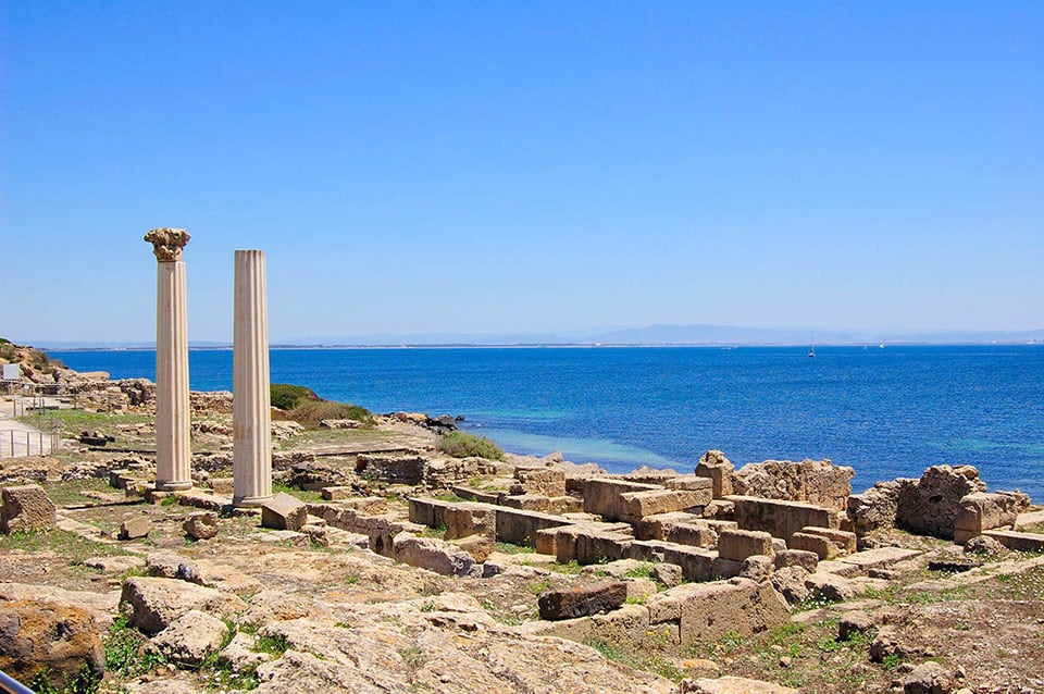 Die Säulen der archäologischen Stätte Tharros mit dem wunderschönen sardinischen Meer im Hintergrund